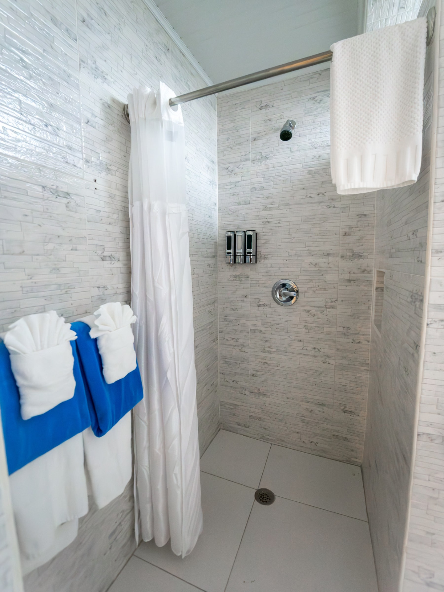 One Bedroom tiled walk-in shower with marble-look walls