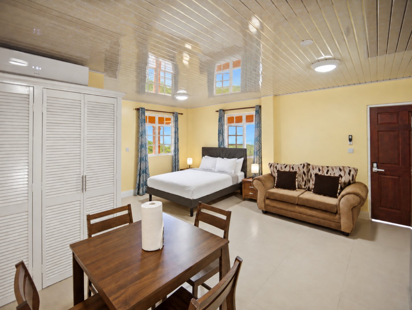 Studio with queen bed, sofa and dining table